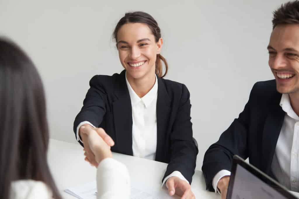 smiling female hr handshaking businesswoman group meeting interview